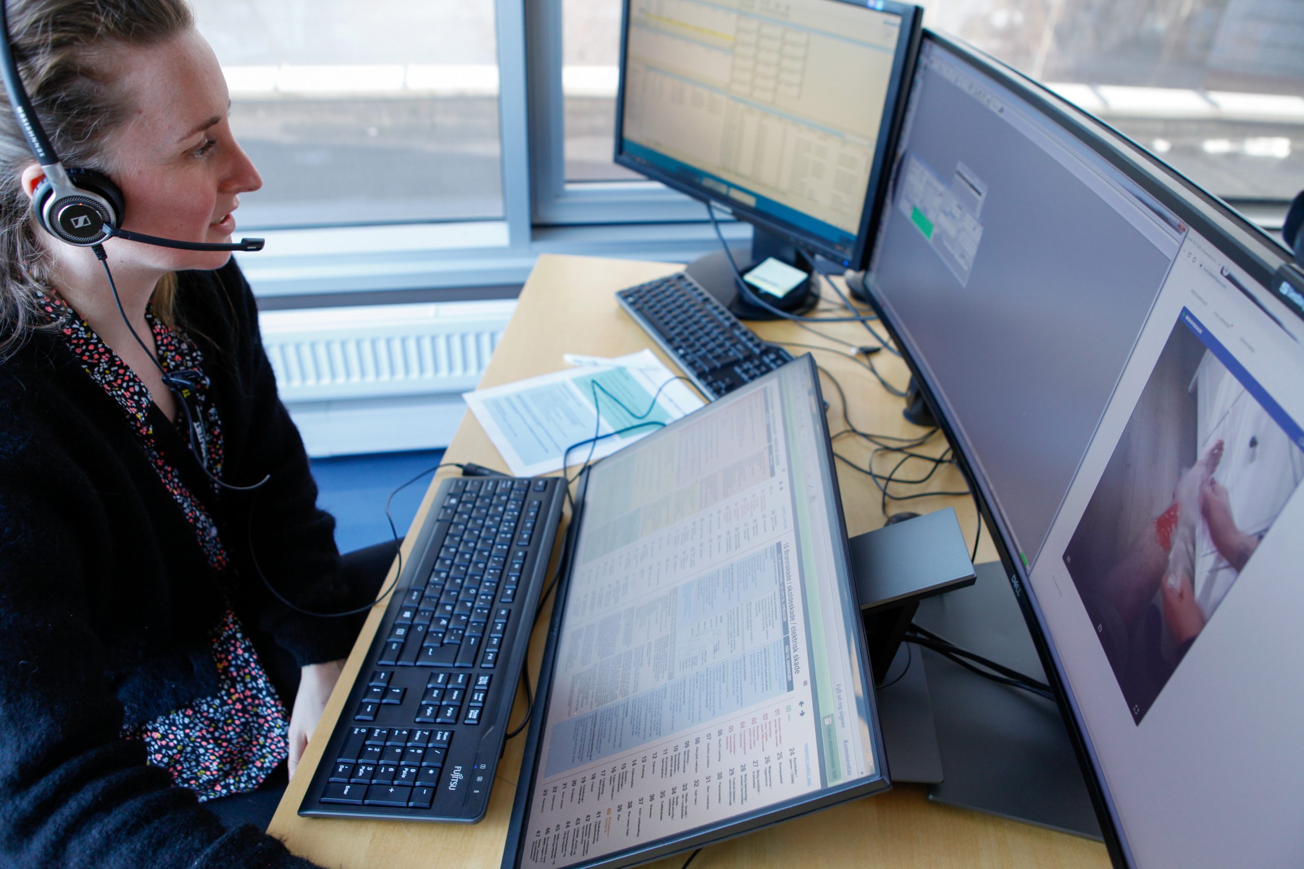 kvindelig sundhedsvisitator ser på computerskærme