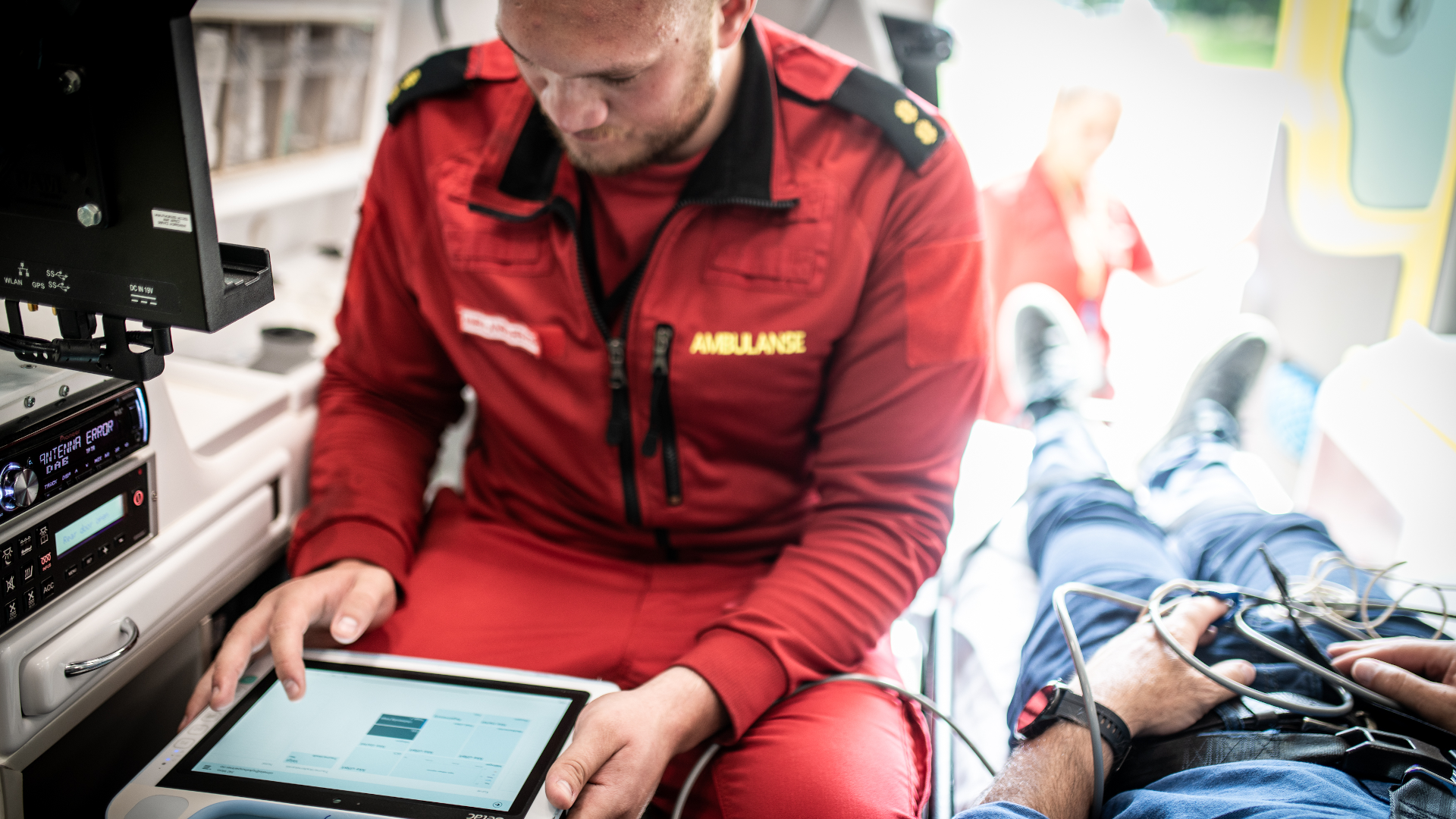 ambulansearbeider ser å tablett i ambulanse